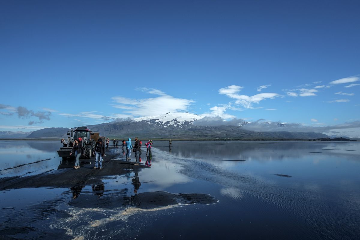 Visitors crossing black sand plains by tractor tour to reach Ingólfshöfði puffin colony in South Iceland Visitors crossing black sand plains by tractor tour to reach Ingólfshöfði puffin colony in South Iceland