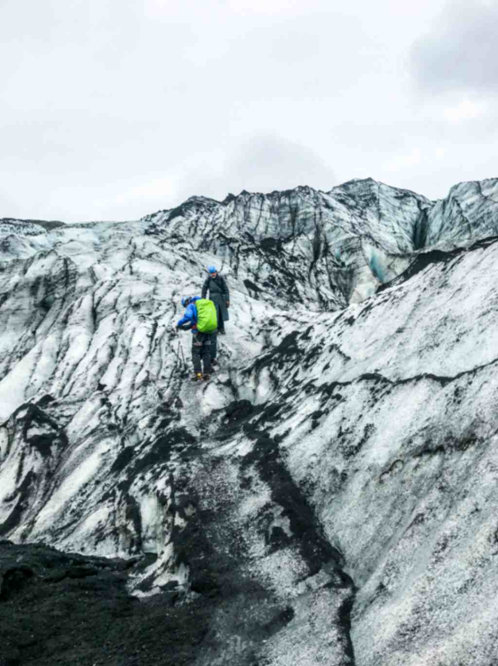 People hiking on Sólheimajökull glacier with safety gear