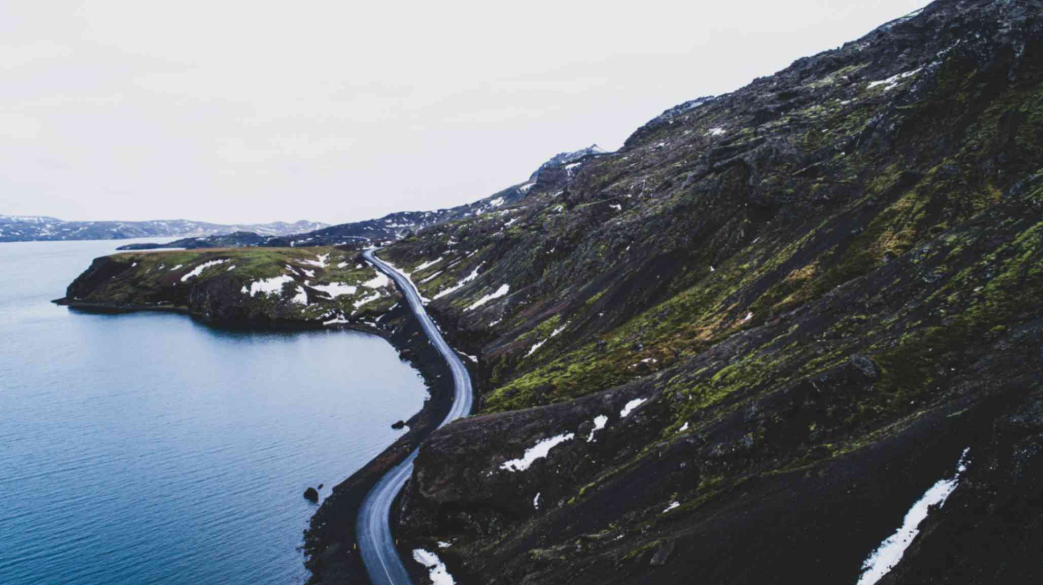 Scenic coastal road winding along fjord coastline in the Eastfjords region of Iceland